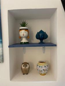 ein Regal mit drei Vasen und einer Eule darauf in der Unterkunft L'Ostrica in Ostuni