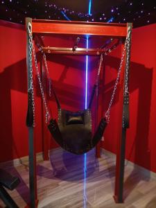 a swing on display in a red room at Appartement Romantique L'Escapade Jacuzzi in Espondeilhan +9 photos