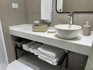 a bathroom with a sink and towels on a shelf at MAO Buenos Aires - Apt. en Recoleta in Buenos Aires
