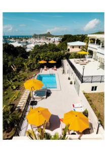 a view of a pool with umbrellas and a swimming pool at Oasis with Pool Hot Tub & Sauna in Rodney Bay Village