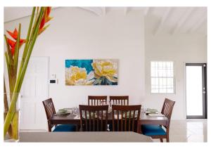 a dining room with a table and chairs and a painting at Oasis with Pool Hot Tub & Sauna in Rodney Bay Village
