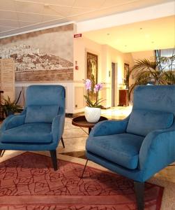 two blue chairs and a table in a lobby at Hotel Ariston in Imperia