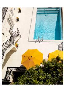 two yellow umbrellas sitting next to a swimming pool at Luxurious Oasis for groups in Rodney Bay Village