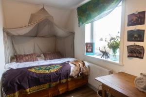 a bedroom with a canopy bed with a dog laying on it at Duveslätt B & B in Åskloster