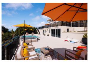 un patio con sedie e ombrelloni accanto alla piscina di Sauna Pool Game Room Bliss a Rodney Bay Village