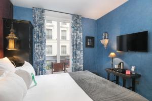 sypialnia z łóżkiem i telewizorem na ścianie w obiekcie R. Kipling by Happyculture w Paryżu