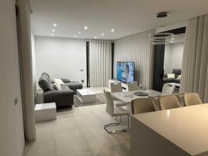 a living room with a couch and a table and chairs at Luksus i Alicante in Alicante