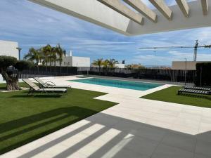 a swimming pool with two lounge chairs next to a yard at Luksus i Alicante in Alicante