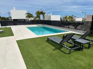 a swimming pool with two chairs and a bench next to it at Luksus i Alicante in Alicante