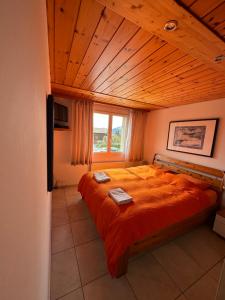 een slaapkamer met een groot bed en een houten plafond bij Ferienwohnung Arvenbüel Bergtraum über Amden in Amden