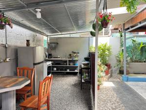 a kitchen with a refrigerator and a table and some plants at Cabinas Las Palmas del Sol in Fortuna