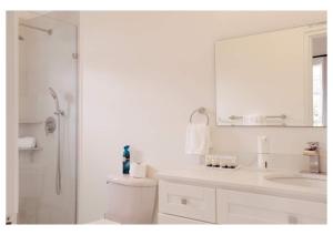 un bagno con lavandino, water e specchio di Sauna Pool Game Room Bliss a Rodney Bay Village
