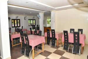 una sala da pranzo con tavoli e sedie rosa e neri di Hotel Sea Rock Porte Blair a Port Blair