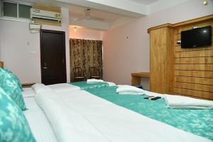 a row of beds in a hotel room at Hotel Sea Rock Porte Blair in Port Blair