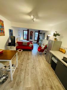 uma sala de estar com um sofá vermelho e uma mesa em La Cite No 25 superbe apartment plein centre calme ,Netflixl em Mirepoix