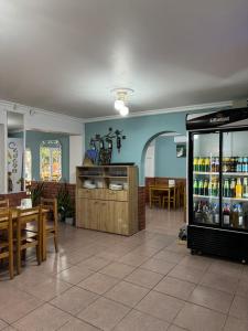 un ristorante con frigorifero per bevande, tavoli e sedie di Гостевой дом при кафе оазис a Kobuleti