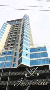 un edificio alto azul con un cartel delante en Triann Condo Staycation Davao in Inspiria Condominium Building, en Davao City