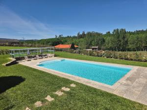 - une piscine au milieu d'une pelouse dans l'établissement Quinta Carolina, à Póvoa de Lanhoso