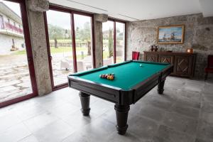 a pool table in a room with windows at Quinta Carolina in Póvoa de Lanhoso