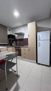a kitchen with a white refrigerator and a table at Chez-moi in Sfax
