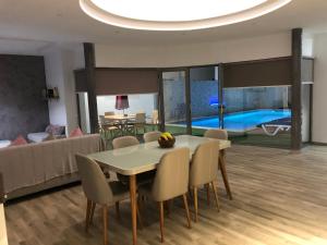 a dining room with a table and chairs and a couch at VILLA ALOHA DJERBA plain pied haut de gamme piscine proche de la plage in Midoun