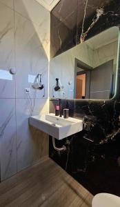 uma casa de banho com um lavatório branco e um espelho. em Sountou home em Xanthi