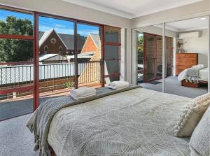 a bedroom with a large bed and a balcony at Glenmore Lodge - CBD Location, Hidden Gem in Dubbo