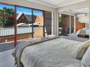 达博Glenmore Lodge - CBD Location, Hidden Gem的一间带大床的卧室和一个阳台