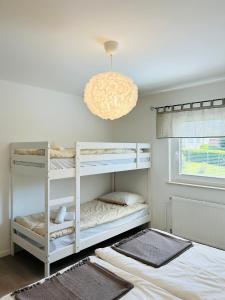 a bedroom with two bunk beds and a chandelier at Apartma Jana in Žirovnica