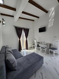 a living room with a couch and a table with chairs at One-bedroom apartment, 5 min from the Airport Tivat in Mrčevac
