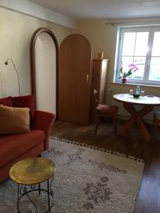 a living room with a red couch and a table at Haus Diana in Badenweiler