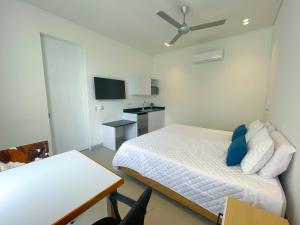 Schlafzimmer mit einem Bett mit blauen Kissen und einem Tisch in der Unterkunft Apartaestudio Brumilo 3 in Montería