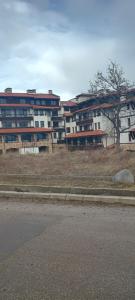 un bâtiment situé sur le côté d'une route à côté d'une rue dans l'établissement Hotel Casa karına bansko, à Bansko