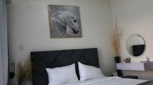 a bedroom with a picture of a horse on the wall at Triann Condo Staycation Davao in Inspiria Condominium Building in Davao City