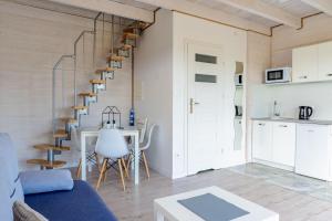 una sala de estar con una escalera de caracol y una mesa en Cichy Domek Apartamenty - Podgrzewany Basen en Karwia