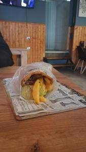 un sandwich et des frites dans un sac en plastique sur une table dans l'établissement Hotel Casa karına bansko, à Bansko