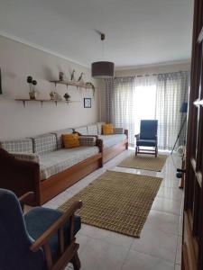 sala de estar con sofá y silla en Brisa do Mar, en Vagos