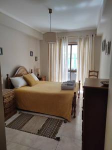 Un dormitorio con una cama grande y una ventana en Brisa do Mar, en Vagos