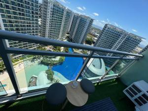 balcón con vistas a la piscina y a los edificios en Bias Haven Azure Urban Resort Residences en Manila