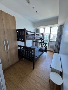 een kleine kamer met 2 stapelbedden en een bureau bij Bias Haven Azure Urban Resort Residences in Manilla