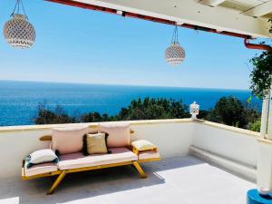 a bench on a balcony with a view of the ocean at Puerto Escondido in Castro di Lecce