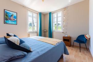 una camera con un letto blu e due finestre di Maison Cap Brun Jardin Parking a Tolone