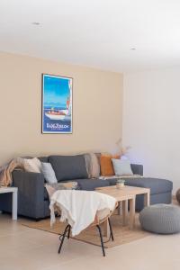 トゥーロンにあるMaison Cap Brun Jardin Parkingの青いソファとテーブルのあるリビングルーム