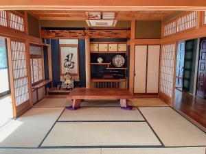 Villa SHINOBI -忍- في Hinase: غرفة يابانية مع مقعد خشبي فيها