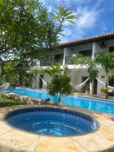 a pool in front of a building with a resort at Milano Hotel Pousada Canoa Quebrada in Canoa Quebrada