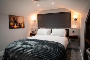 a bedroom with a large bed with a large screen at Chestnut retreat a stunning Annex apartment in Ossett
