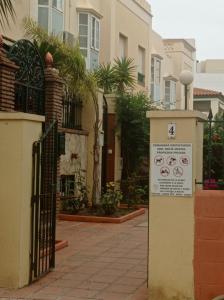 una puerta con un cartel delante de un edificio en AyD, en Nerja