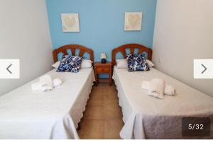 Dos camas una al lado de la otra en una habitación. en AyD, en Nerja