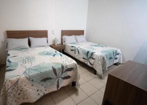 Calvillo的住宿－Casa Roma，一间卧室配有两张床和一张桌子