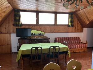 a living room with a table and a couch at CASA PINUCCIA MANSARDA in Predazzo